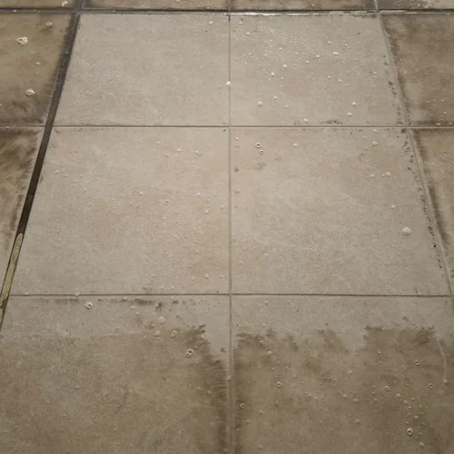 Piso externo com placas centrais limpas cercadas por oxidação após aplicação do Eficaz Limpa Pisos