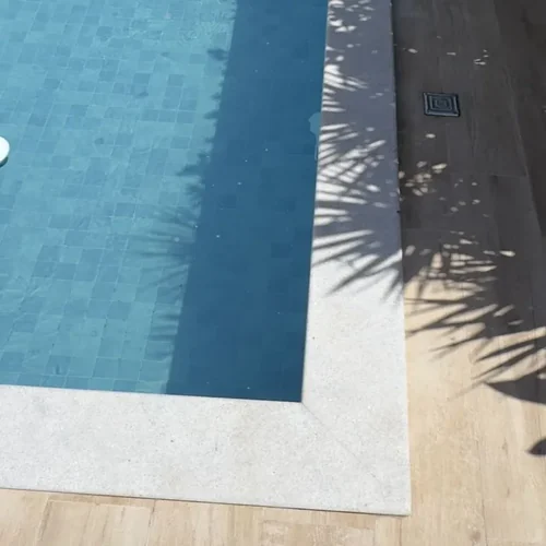 Borda de piscina em pedra clara limpa após aplicação do Eficaz Limpa Pisos