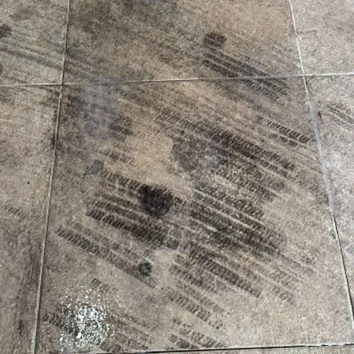 Piso com marcas escuras de pneu impregnadas antes da limpeza